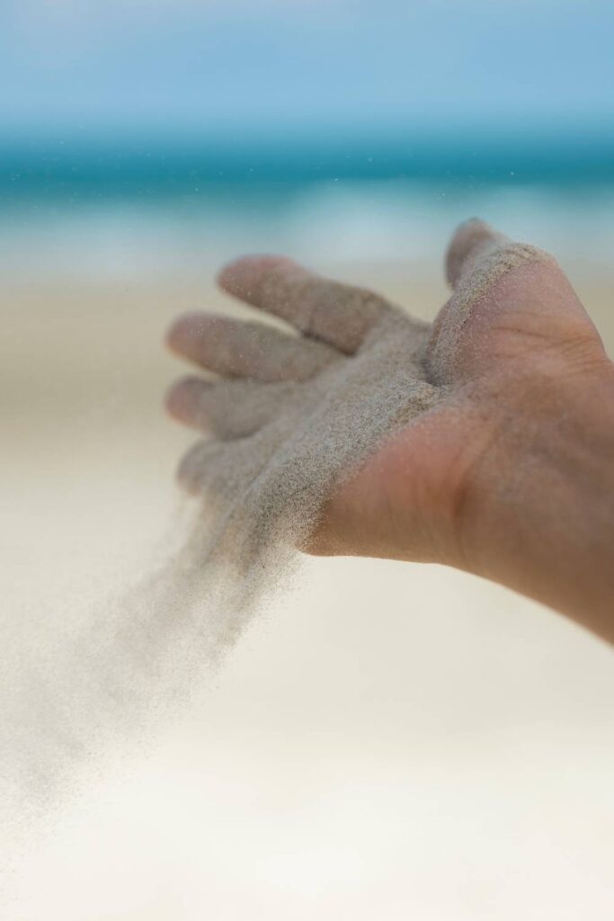 hand releasing sand as a metaphor for forgiveness and letting go of resentment
