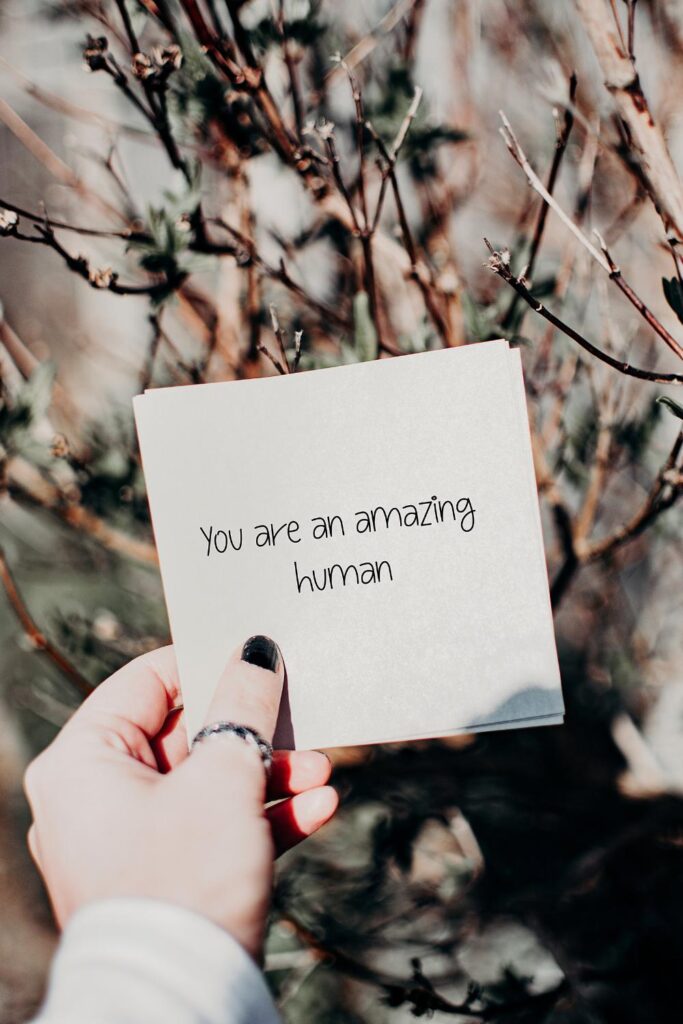 woman holding a card with positive affirmations written on it