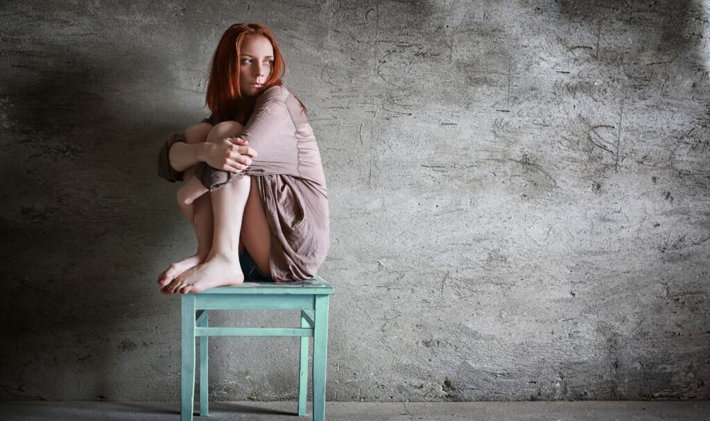 Woman sitting alone with anxious thoughts and emotional overwhelm, representing the need for affirmations for anxiety and inner calm.