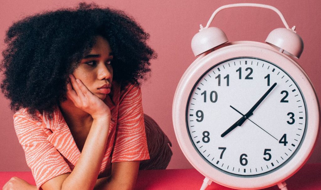 Woman looking at a clock while learning how to reprogram your subconscious mind and change limiting habits