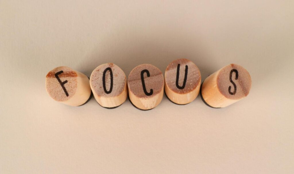 Wooden blocks spelling the word focus on a neutral background