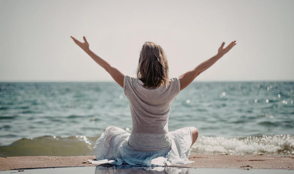 Mindfulness meditation for focus by the sea with open posture and relaxed awareness