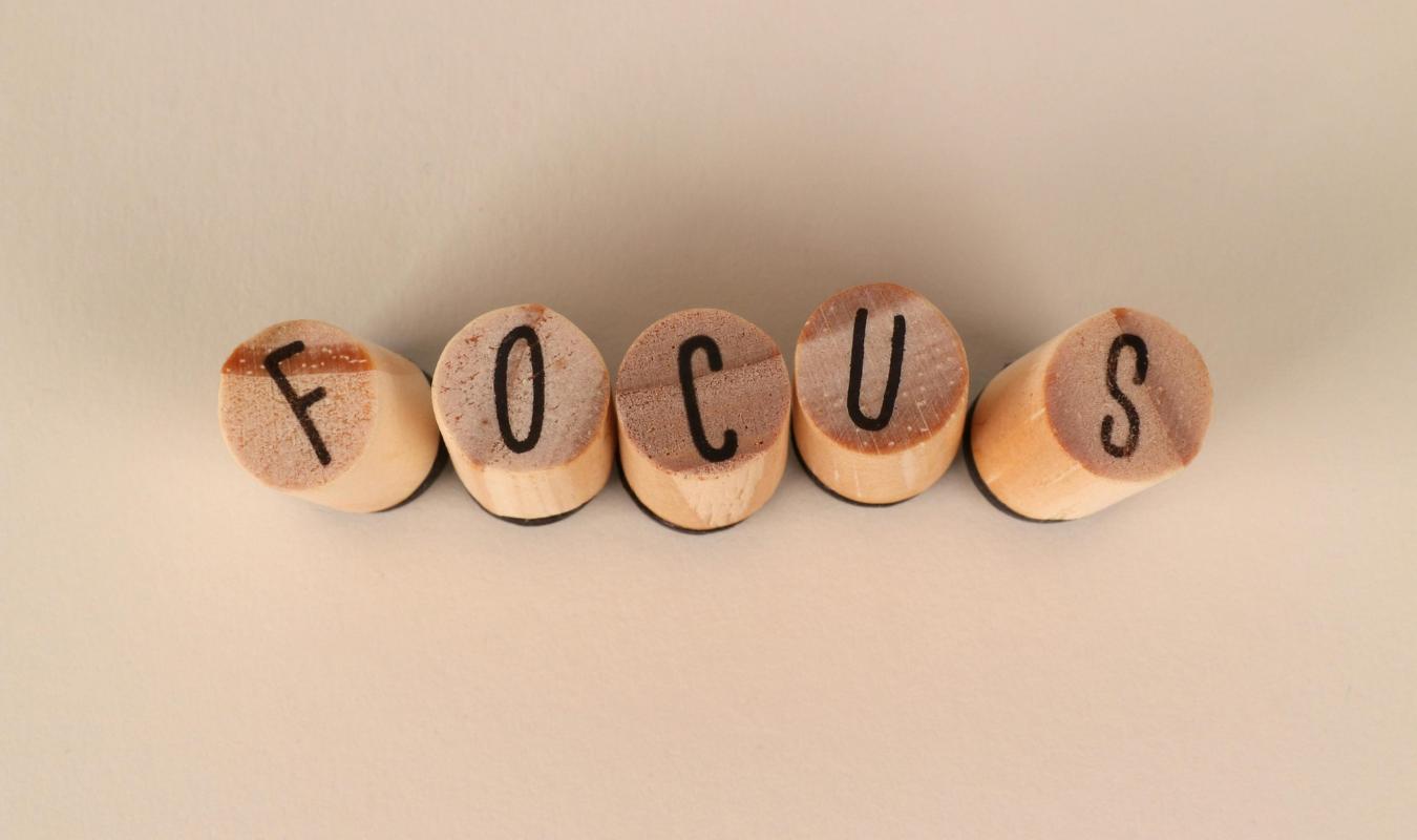 Wooden blocks spelling the word focus on a neutral background